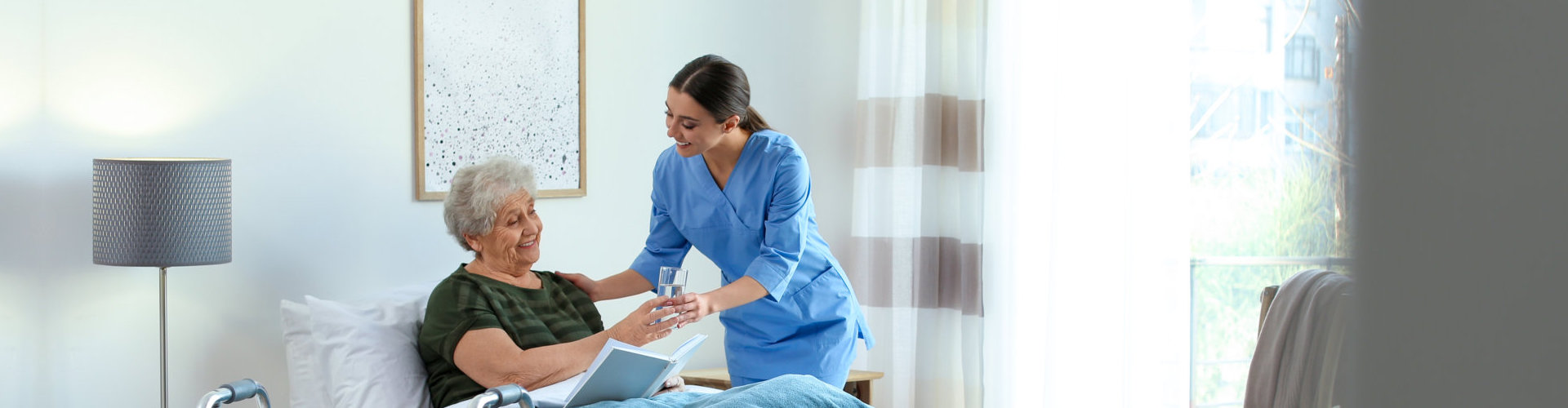 healthcare staff helping senior woman to drink water